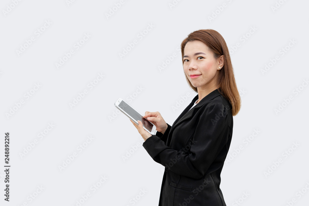 Happy asian business woman using tablet device in black suit isolated on white color background Happy asian business woman using tablet device in black suit isolated on white color background