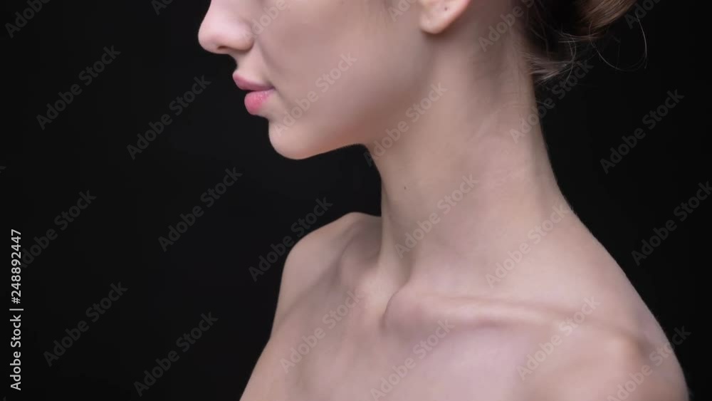 Close-up portrait in profile of female collarbone on black background. Close-up portrait in profile of female collarbone on black background.