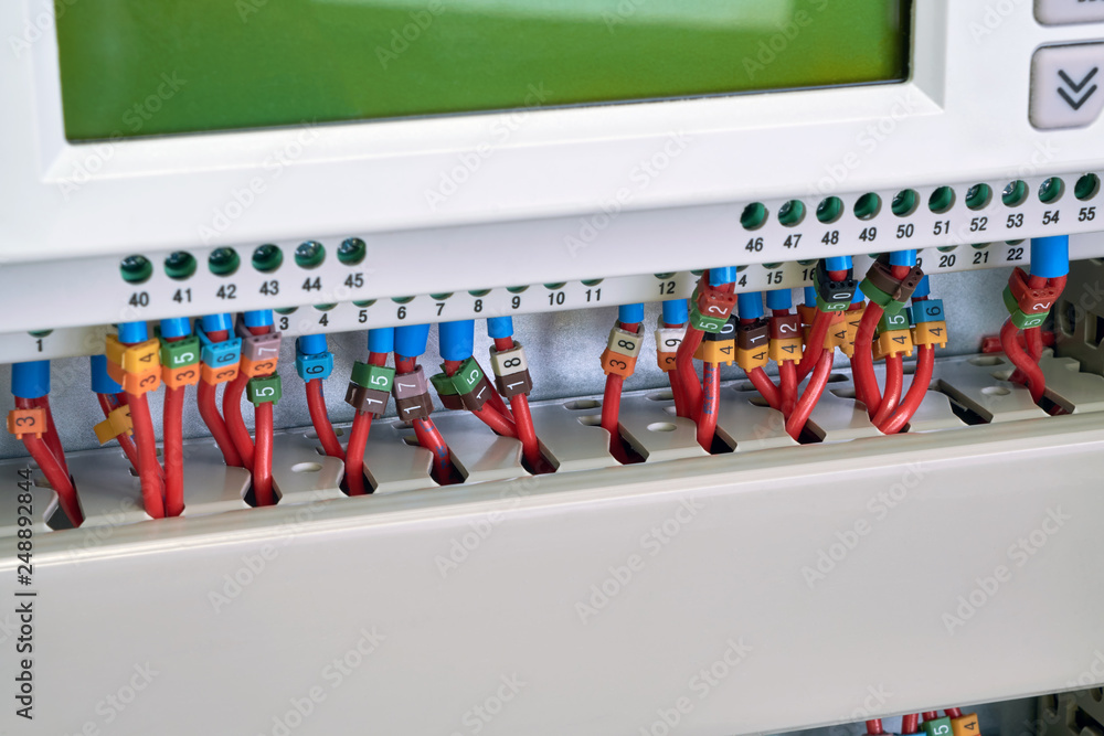 Operator panel or controller with wires connected to it with marking. Electrical cables are connected according to the scheme or project. Modern management and automation in the power industry.