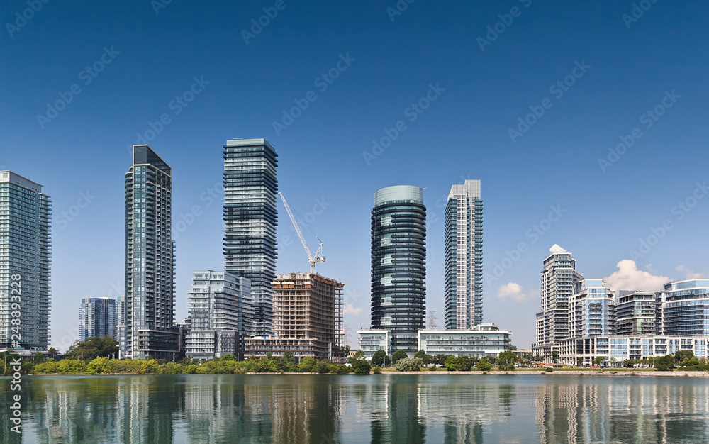 Obraz premium Waterfront skyline with construction of residential high rise buildings on blue sky