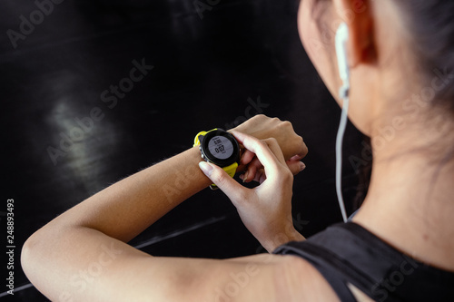 Fototapeta Naklejka Na Ścianę i Meble -  Young woman workout in gym healthy lifestyle using smart watch and application. Technology and sport concept.