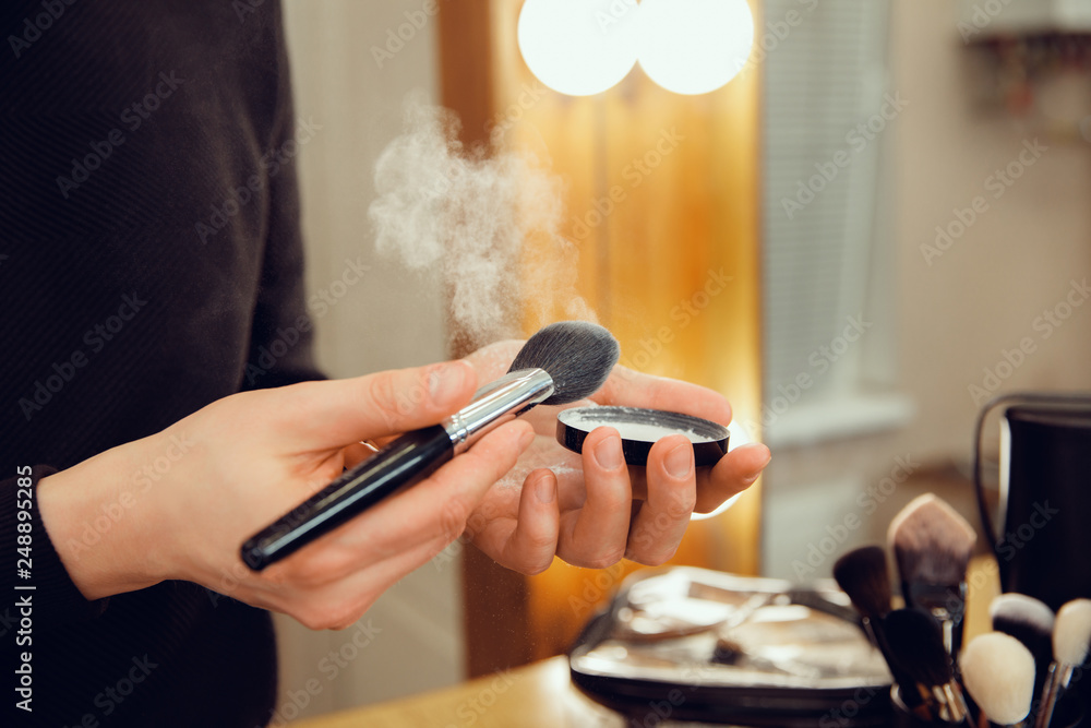 Professional makeup artist working at salon. The man in female proffesion. Gender equality concept. Male hands with brush closeup Professional makeup artist working at salon. The man in female proffesion. Gender equality concept. Male hands with brush closeup