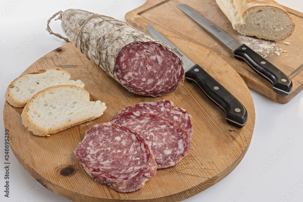 salame tagliato su tagliere di legno con pane