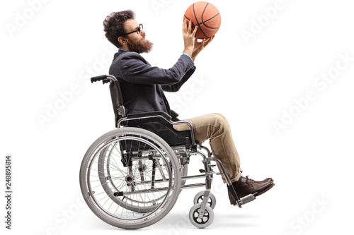 Young man in a wheelchair holding a basketball