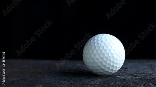 Golf ball on dark background with copy space
