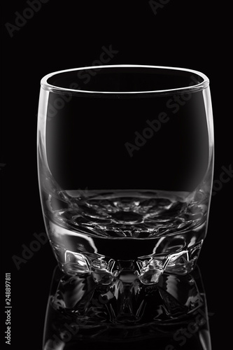 Empty glass on black background with highlights.