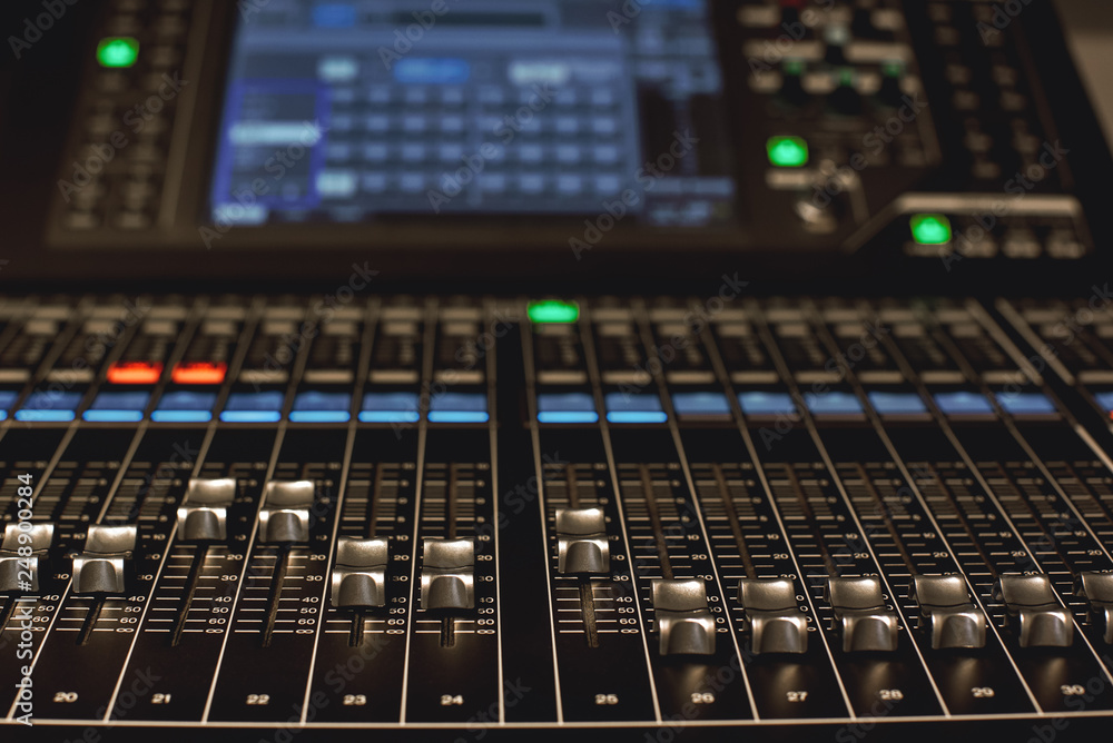 Digital Audio mixing console. Close-up view of professional equipment for sound mixing. Focus on audio control buttons