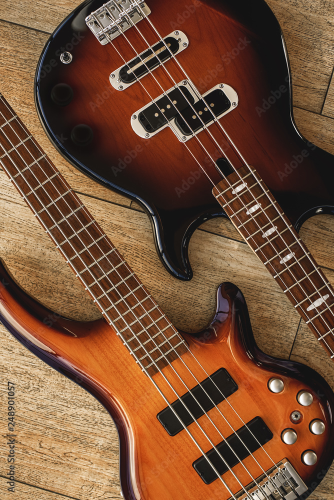 Perfect sound. Top view of the different electric guitars lying close to each other against of the wooden floor. Music concept. Perfect sound. Top view of the different electric guitars lying close to each other against of the wooden floor. Music concept.