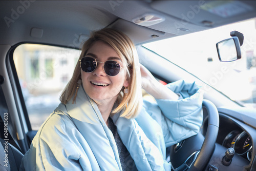 Girl behind the wheel in sunglasses