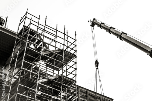 building construction on the background of a boom. slings on arm of crane and scaffolding