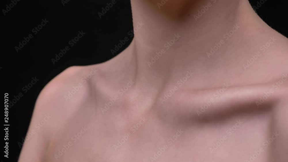 Close-up portrait of skinny female collarbone moving on black background. Close-up portrait of skinny female collarbone moving on black background.