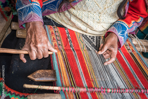 Hands of Peruvian weaver making a striped textile photo