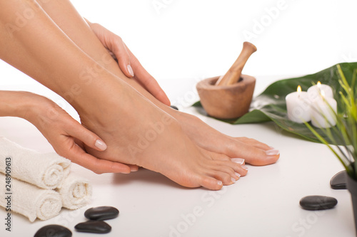 The picture of ideal done manicure and pedicure. Female hands and legs in the spa spot in the white background. photo