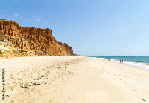 High cliffs along Falesia Beach and The Atlantic Ocean in Albufeira, Algarve, Portugal. Sunny summer day, blue sky.