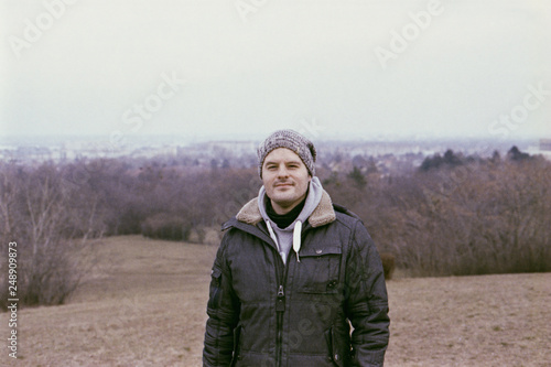 Adult man standing on a hill in the winter or autumn time