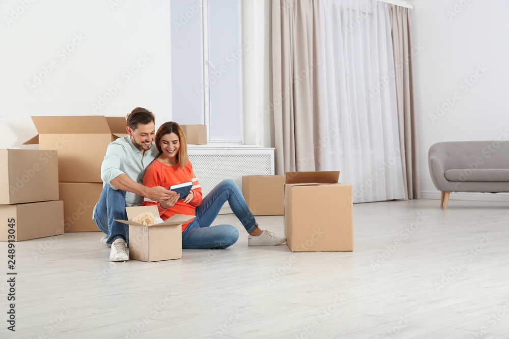 Couple unpacking moving boxes in their new house Couple unpacking moving boxes in their new house