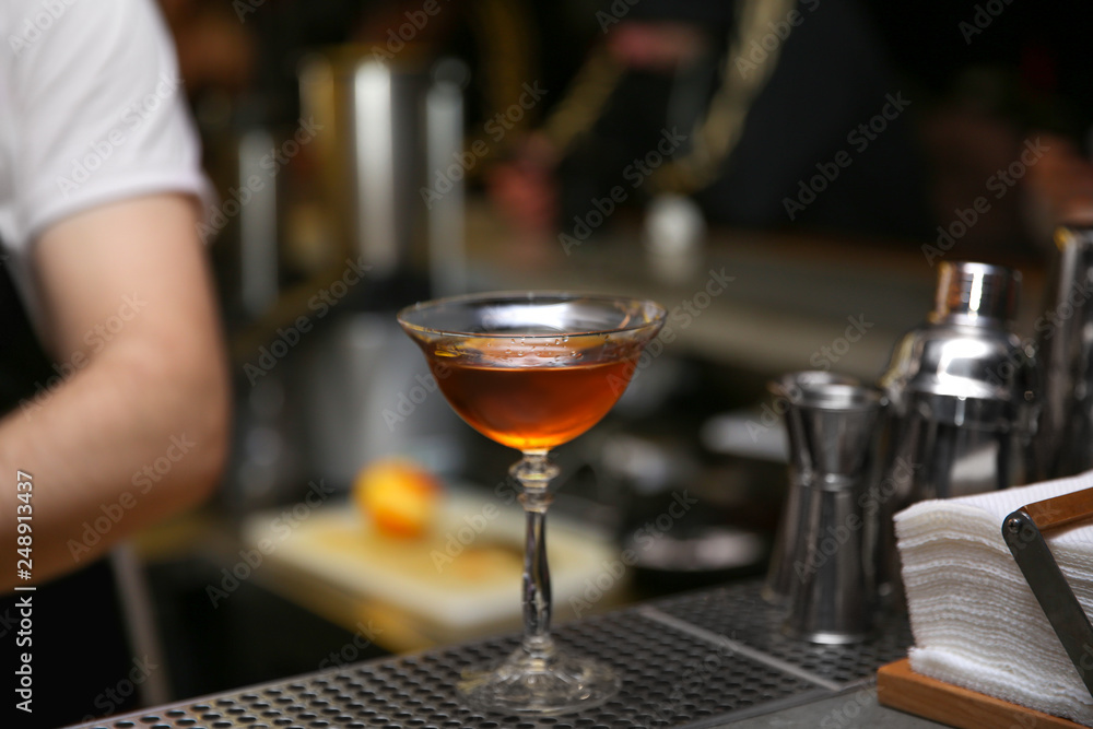 Glass of tasty cocktail on bar counter