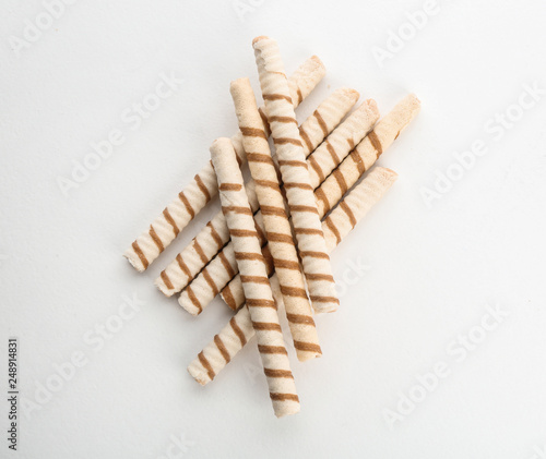 Delicious wafer rolls on white background, top view. Sweet food