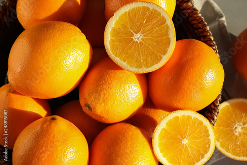 Fresh juicy oranges in wicker basket on table  top view