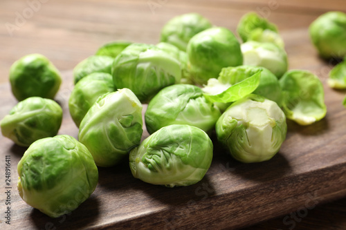 Wooden board with Brussels sprouts on table, closeup