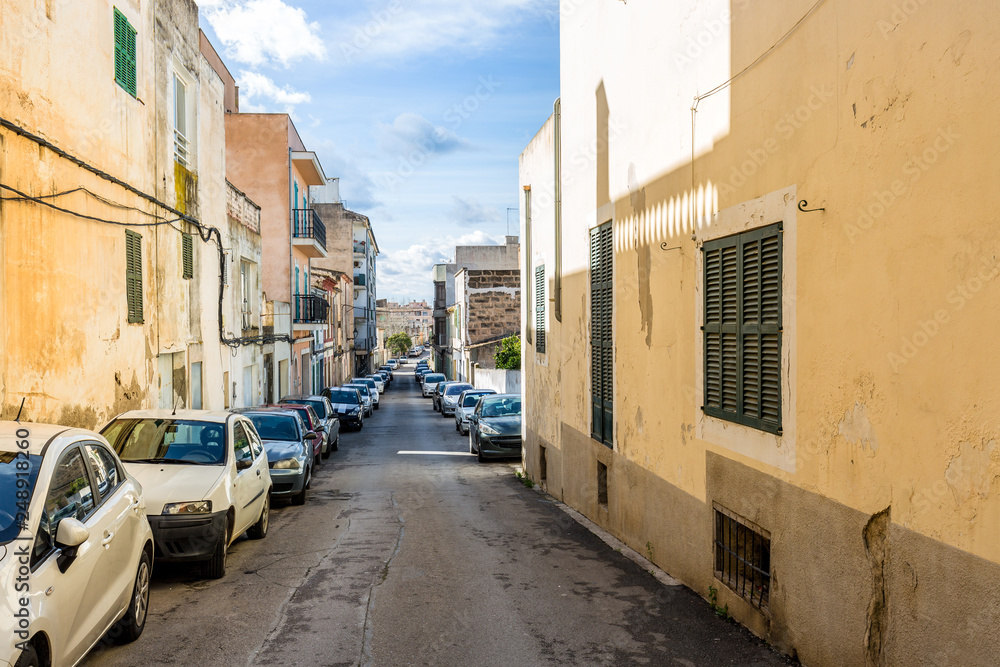 Eine typische, mediterrane Gasse mit parkenden Autos auf Mallorca