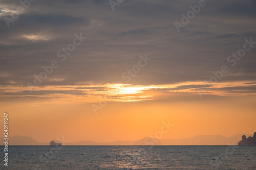 Sunset on the sea with a coastal strip on the horizon