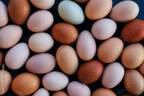 Flat lay of earthy tones of organic farm eggs arranged as a background.