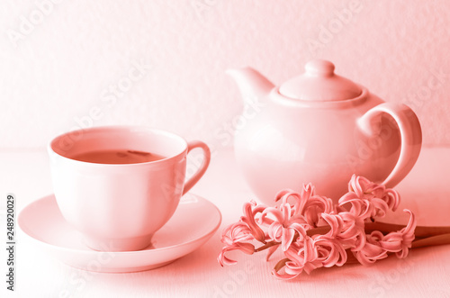 Live coral color is a composition of a teapot and a cup of tea. Fragrant hyacinth