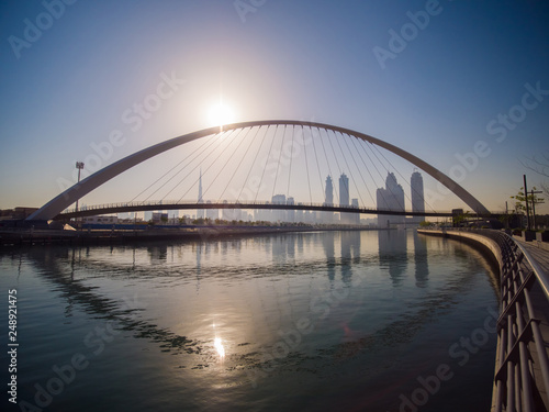 Fototapeta Naklejka Na Ścianę i Meble -  Panorama of the city early in the morning at dawn with a bridge over the city channel Dubai Greek.