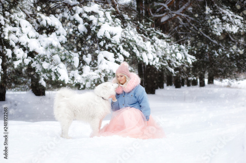 beautiful girl with a dog on a walk in the winter forest. beautiful girl and her pet. © SatrianiPh 