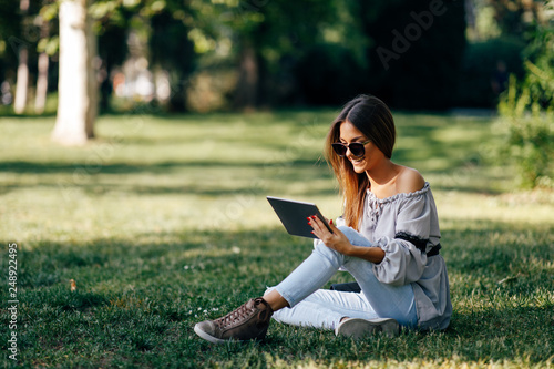Young woman using a digital tablet in the park