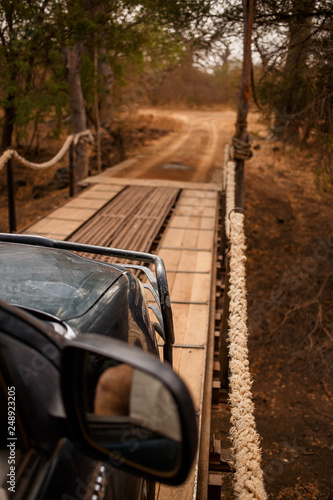 Jeep safari going through hinged bridge. Wild life in Safari. Baobab and bush jungles in Senegal, Africa. Bandia Reserve. Hot, dry climate. Vertical view from outside the car