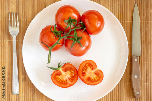 Fresh natural tomatoes on plate © Sergei Gorin