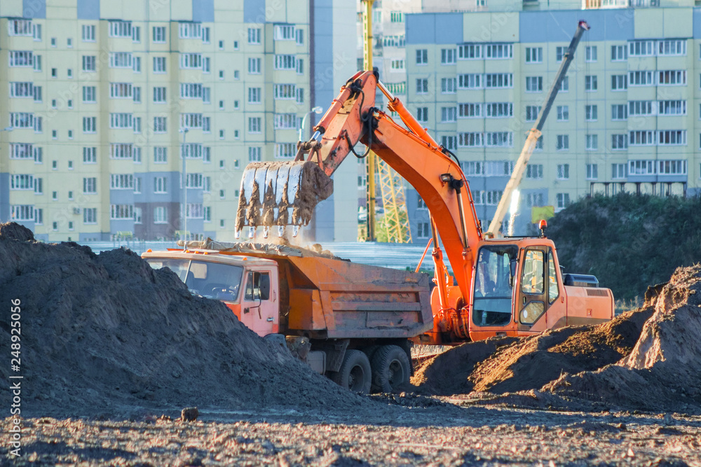 Excavator loads the earth into a dump truck. Excavator loads the earth into a dump truck.