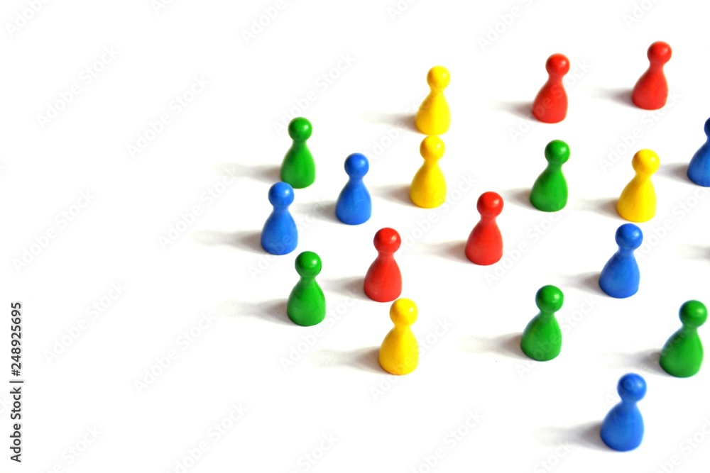 Game figures from a board game in different colors stand on a white background and throw all the shadows in one direction - concept with different figures on white background Game figures from a board game in different colors stand on a white background and throw all the shadows in one direction - concept with different figures on white background