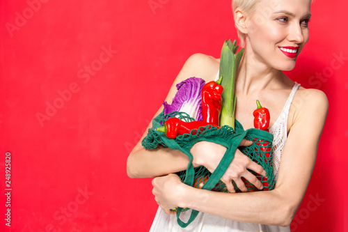 Portrait of beautiful caucasian woman holding grocery bag. Healthy lifestyle concept, vegetables, diet