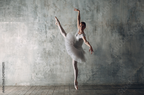 Fototapeta Naklejka Na Ścianę i Meble -  Ballerina female. Young beautiful woman ballet dancer, dressed in professional outfit, pointe shoes and white tutu.