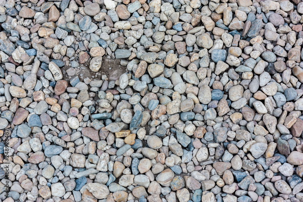 Natural colorful pebble (stones) background texture with copy space.