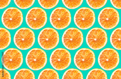 Cut orange fruit sections. Round slices pattern design isolated on blue background. 
