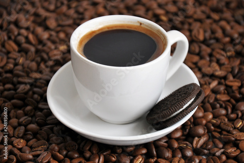 cup of coffee and cookie with beans background