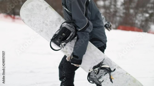 Close Up of Walking Man Hand Holding Snowboard 
