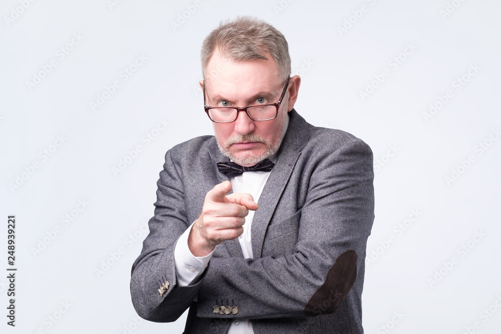 Angry senior man pointing finger at you forcing you to make a choice. Angry senior man pointing finger at you forcing you to make a choice.