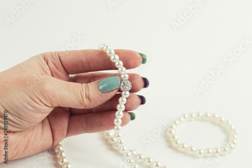 Stylish fashionable women's mint and blue nail Polish. Hands of beautiful young woman with pearl on white background