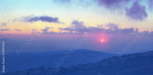 sunset over mountain top, winter mountain range panorama © night_cat
