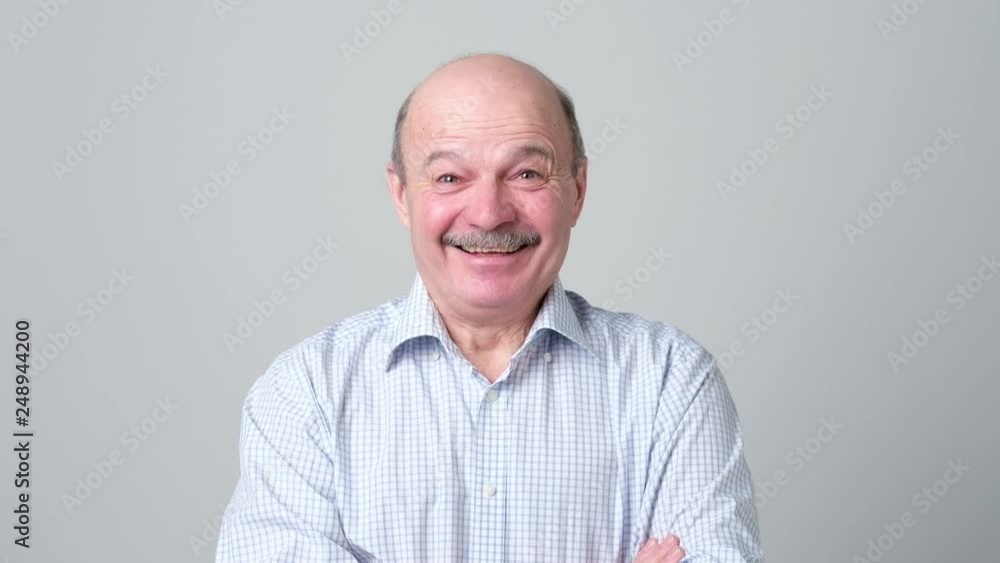 Mature adult man laughing looking at the camera. Positive emotion concept Mature adult man laughing looking at the camera. Positive emotion concept