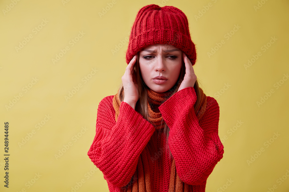 Ill girl in the red sweater standing on the yellow background, sore throat Ill girl in the red sweater standing on the yellow background, sore throat