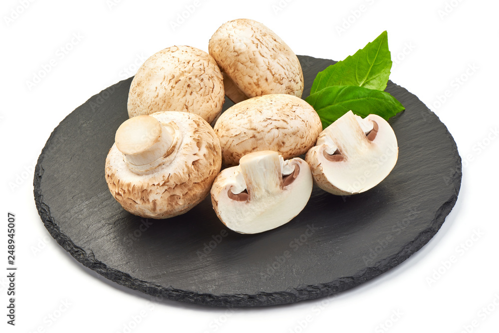 Champignons on a slate shale plate with basil, close-up, isolated on white background Champignons on a slate shale plate with basil, close-up, isolated on white background