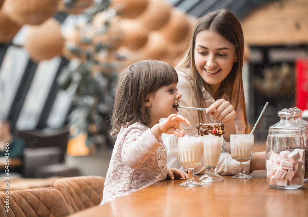 Happy young women mother with children drinking a milkshake Happy young women mother with children drinking a milkshake