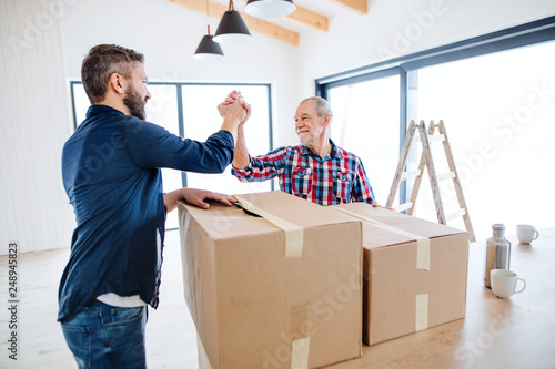 A mature man with his senior father furnishing new house, a new home concept. photo