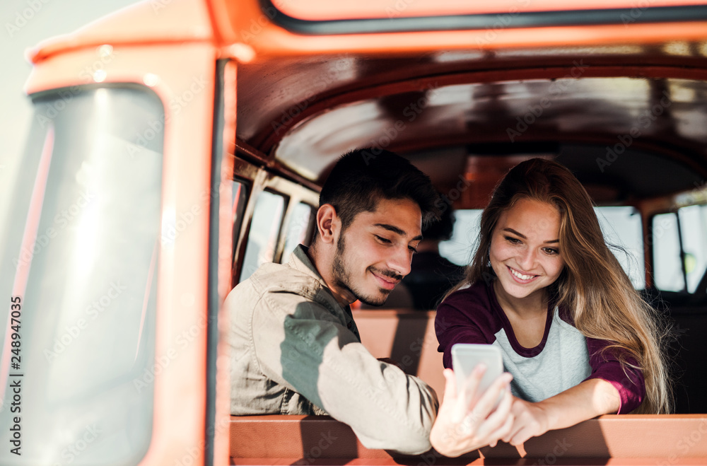 A group of young friends on a roadtrip through countryside, taking selfie. A group of young friends on a roadtrip through countryside, taking selfie.